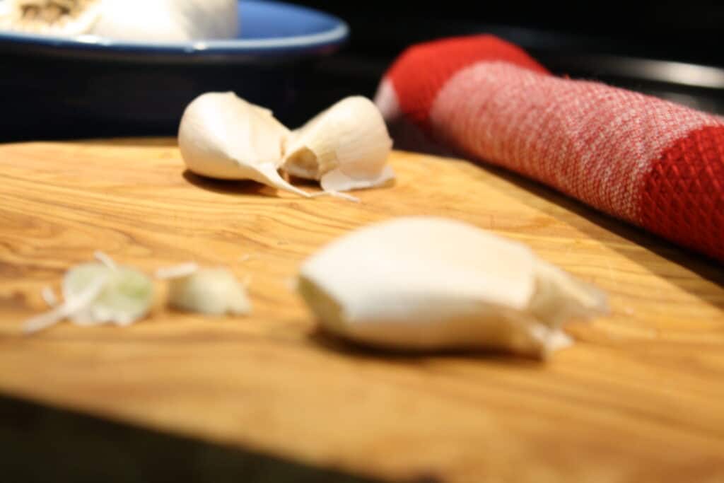 Garlic clove with top and bottom trim. How to Peel and Mince Garlic.