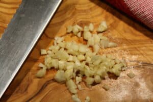 Minced garlic on a cutting board.