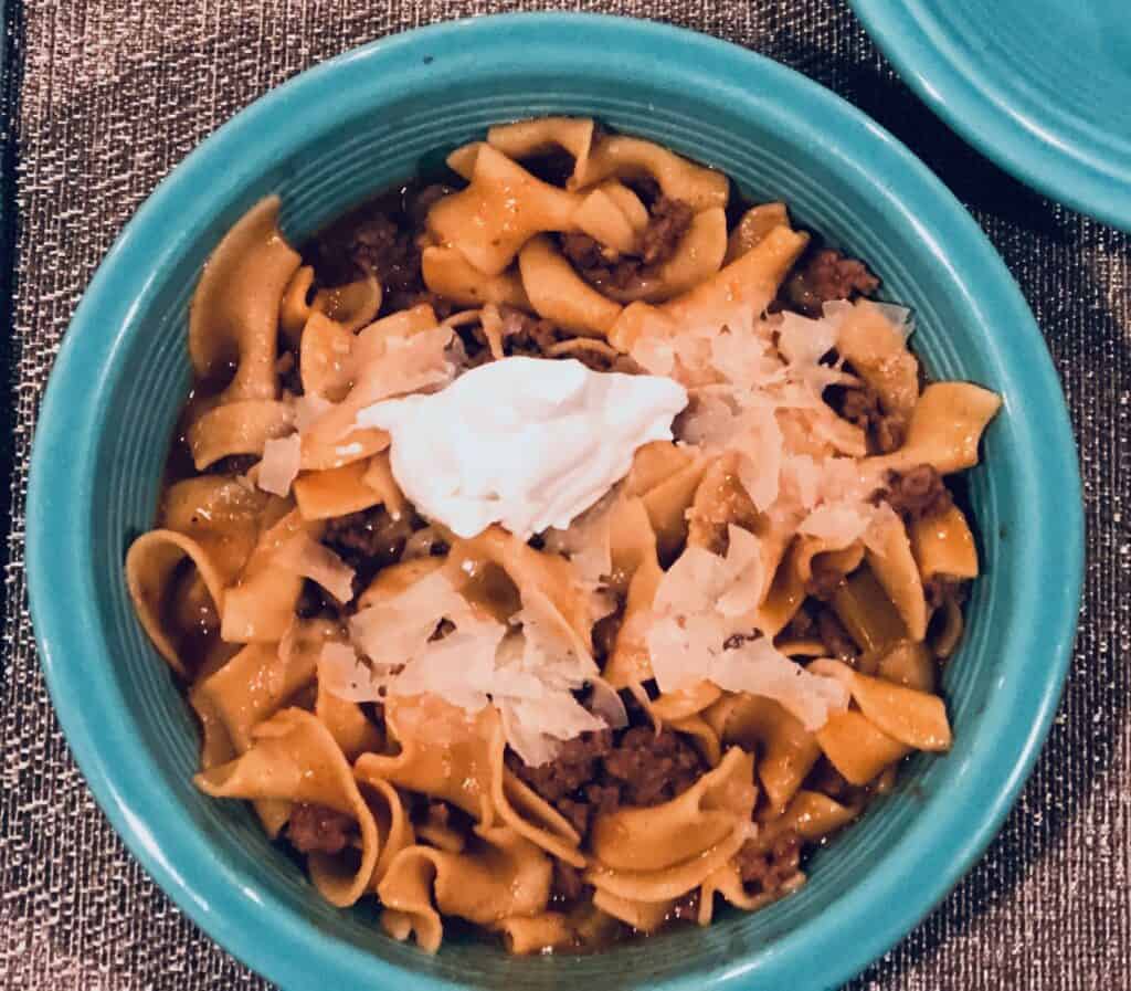 Beef Stroganoff in a blue bowl with sour cream