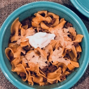 Beef Stroganoff in a blue bowl with sour cream