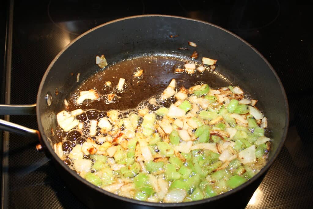 Celery and onion sautéed in a pan