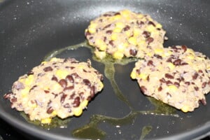 Frying veggie burger patties in a pan with olive oil