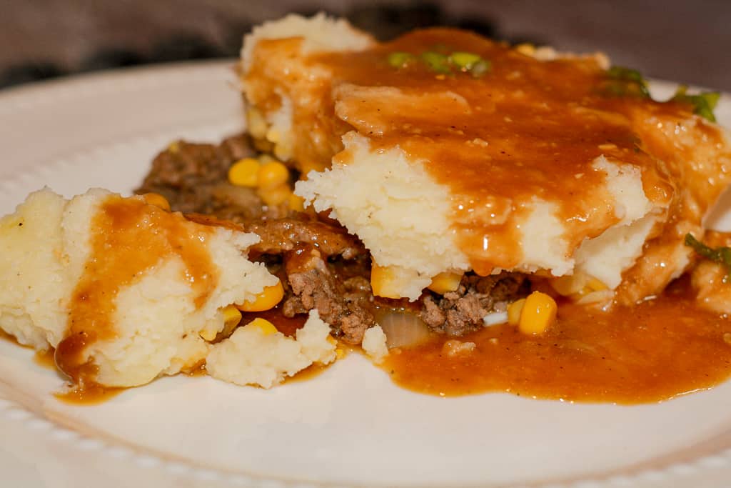 Shepard's Pie on a plate smothered in gravy.