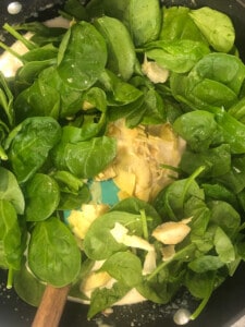 Adding fresh Spinach to the pan for artichoke dip