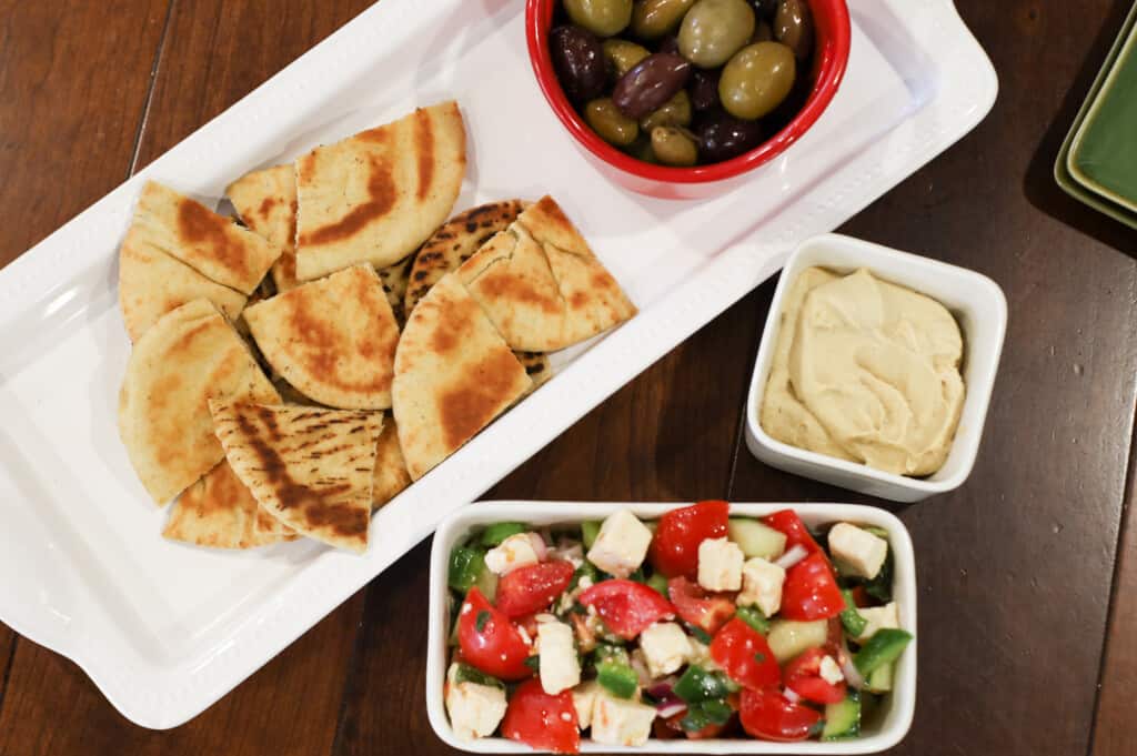Mediterranean Greek Salad Dip with pita and olive over to the side