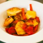 Skillet potatoes with carrots and tomatoes in a white bowl