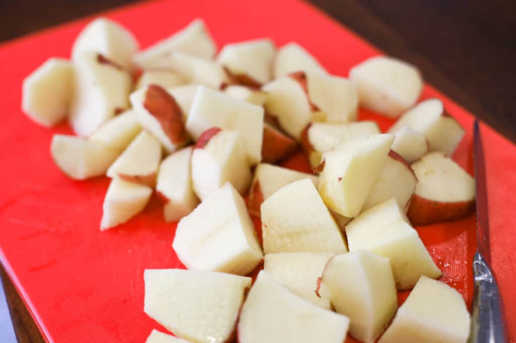 Diced red potatoes on a red cutting board
