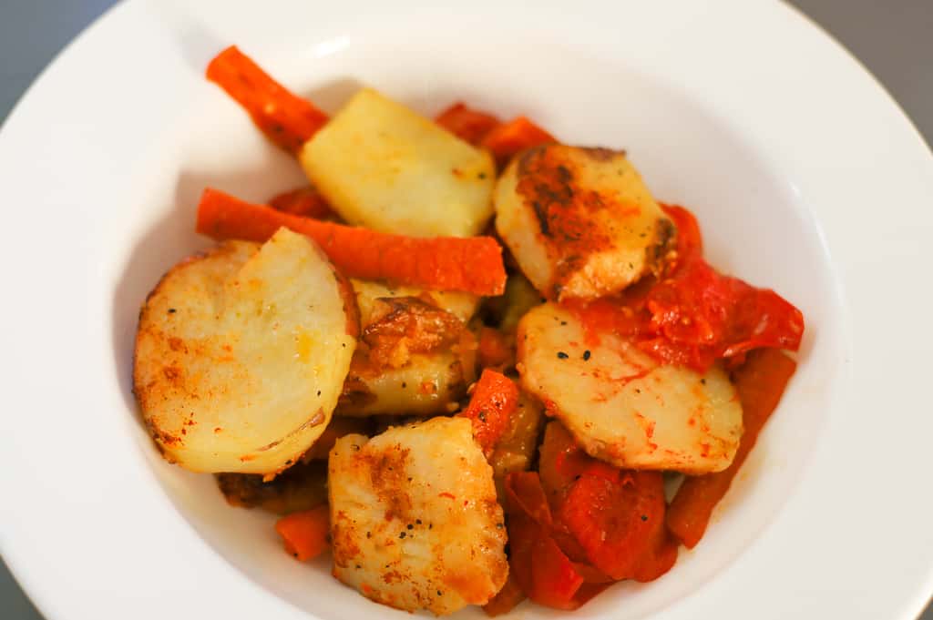 potatoes and carrots recipe pan fried in a white bowl