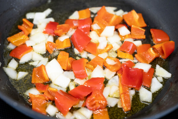 Red peppers and onions frying in a skillet