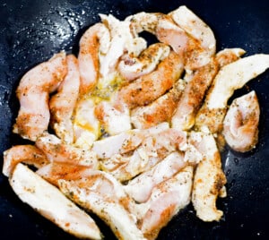 Chicken strips frying in a skillet