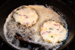 easy potato pancakes frying on the stovetop in a skillet.
